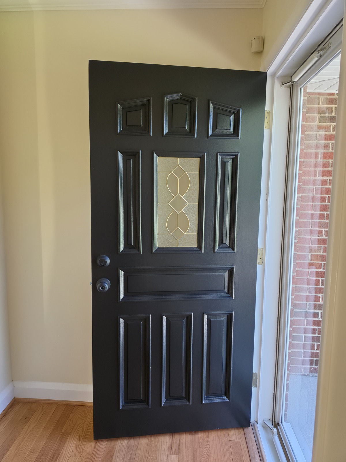 Black entry door with decorative glass and white trim