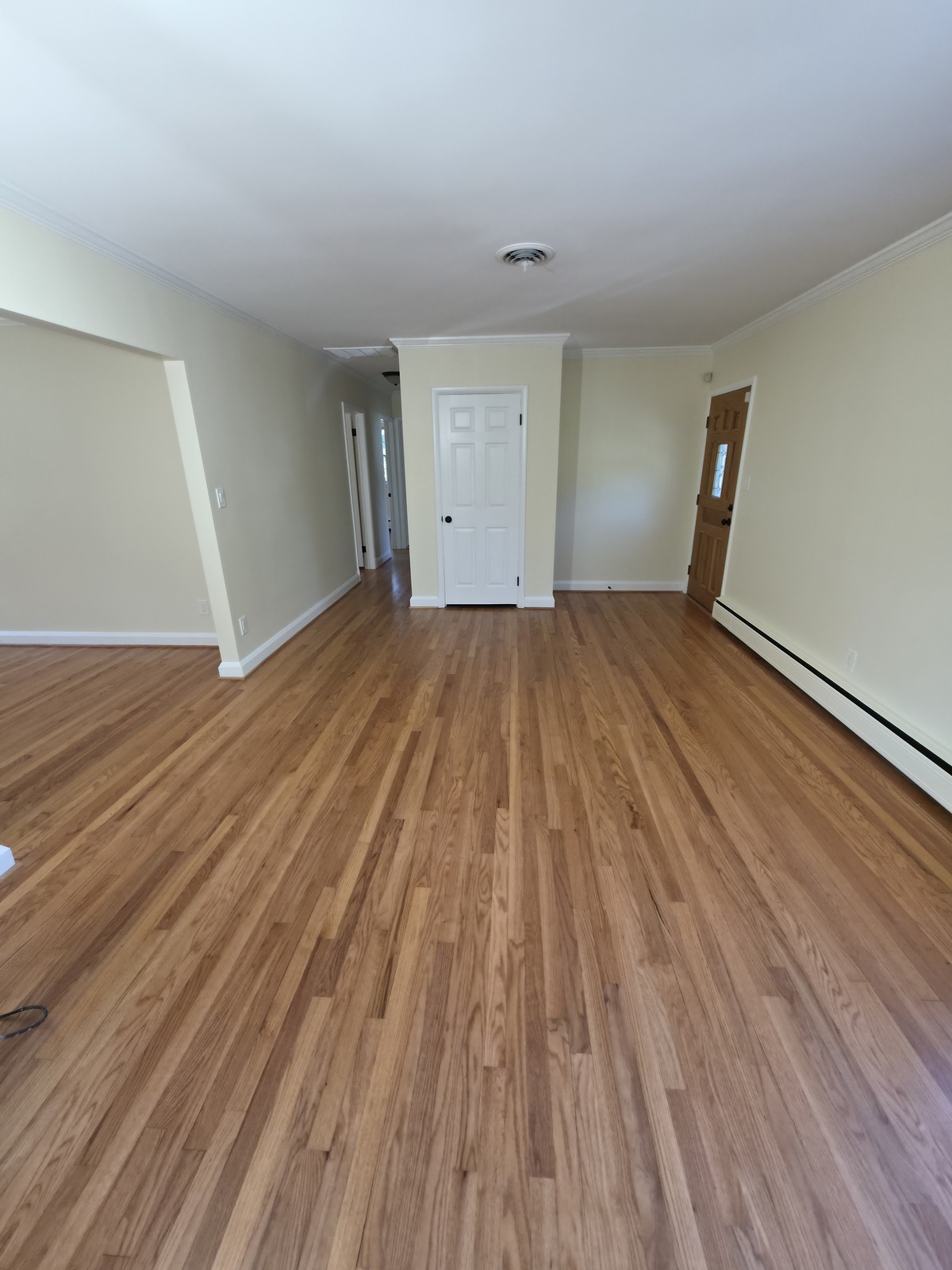 Cream-painted room with refinished hardwood and white closet door